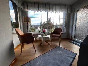 ein Wohnzimmer mit 2 Stühlen, einem Tisch und einem Fenster in der Unterkunft Partzsch Apartment in Wethau