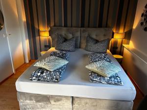 Bett mit vier Kissen auf einem Zimmer in der Unterkunft Partzsch Apartment in Wethau