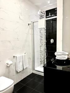 y baño con ducha, aseo y lavamanos. en Les Suites Luxury Bari Certified Italian Excellence en Bari