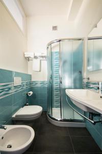 a bathroom with a toilet and a sink and a shower at Hotel Centrale Miramare in Rimini