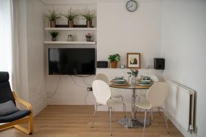 a dining room with a table and chairs and a tv at 1 Bed Apartment in London, 10 minutes from London Bridge in London