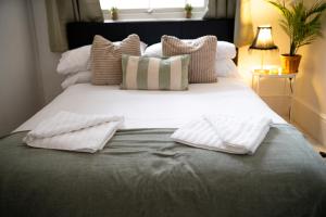 a large bed with white pillows on it at Please do not book in London