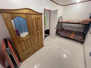 a bedroom with a wooden cabinet and a bunk bed at The Tamarind Tree in Puerto Princesa City
