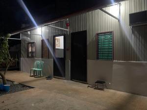 a couple of green chairs sitting outside of a building at The Tamarind Tree in Puerto Princesa City