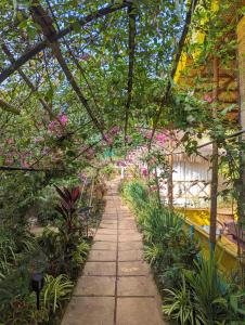 a walkway in a garden with flowers and plants at Cozy Wellness Cocoons in Mandrem