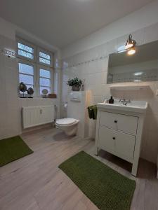 a white bathroom with a toilet and a sink and a sink at Urlaub im Kavaliershaus in Schwerin