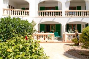 a house with a balcony and a courtyard at La Ardilla in Cala Santanyi
