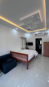 a bedroom with a large bed and a couch at Mali Homestays in Cochin