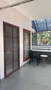 a patio with a bench and a table and a window at Mali Homestays in Cochin