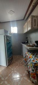 a kitchen with a refrigerator and a table in it at Quitinete em Tartaruga Buzios in Búzios