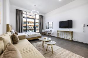 a living room with a couch and a tv at V2 tower Sports city I Studio in Dubai