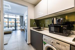 a kitchen with a washer and dryer in a room at V2 tower Sports city I Studio in Dubai