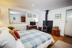 um quarto com uma cama e um fogão a lenha em The Bothy at Oak Farm em Usk