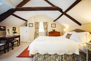 a bedroom with a large white bed and a desk at The Bothy at Oak Farm in Usk