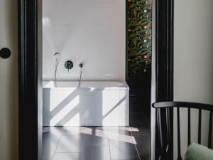 eine weiße Badewanne in einem Zimmer mit Stuhl in der Unterkunft Small Luxury Hotel Altstadt Vienna in Wien