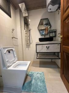 a bathroom with a toilet and a sink and a mirror at Keur Buur in Dakar