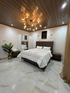 a large bedroom with a large bed and a chandelier at Keur Buur in Dakar
