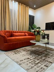 a red couch in a living room with a table at Keur Buur in Dakar