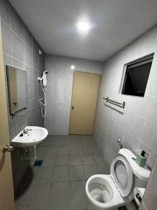 ein Bad mit einem WC und einem Waschbecken in der Unterkunft Fuji In Muji in Sitiawan