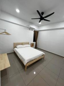 um quarto com uma cama e uma ventoinha de tecto em Fuji In Muji em Sitiawan