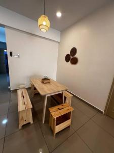 a room with a table and benches and a wall at Fuji In Muji in Sitiawan