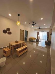 a living room with a table and a ceiling fan at Fuji In Muji in Sitiawan