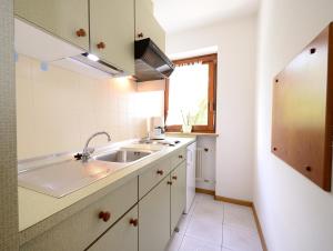 cocina blanca con fregadero y ventana en Residence Bacher en Valdaora