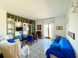 een woonkamer met een blauwe bank en een tafel bij Bright 3 Bedrooms Apartment with Seaview Balcony in Sorrento
