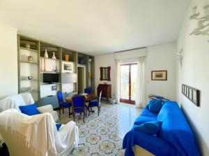 un salon avec un canapé bleu et une table dans l'établissement Bright 3 Bedrooms Apartment with Seaview Balcony, à Sorrente