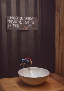 a white bowl on a table with a sign on the wall at Casa loft con opción de tina temperada in Puerto Varas