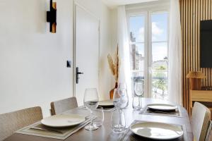 una mesa de comedor con vasos y platos y una ventana en OLYMPIADES - PATAY Beautiful apartment, en París