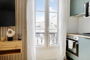eine Küche mit einem großen Fenster und einem Balkon in der Unterkunft OLYMPIADES - PATAY Beautiful apartment in Paris