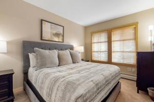 a bedroom with a large bed and two windows at Passage Point 506 in Copper Mountain