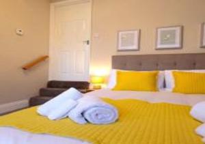 Un dormitorio con una cama amarilla con toallas. en North Bay Cabin 1 Bedroom Apartment Near The Beach, en Scarborough