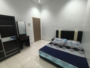 Schlafzimmer mit einem Bett, einer Kommode und einem Spiegel in der Unterkunft HOMESTAY BERTAM SAFAR in Kepala Batas
