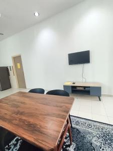 Zimmer mit einem Tisch, Stühlen und einem TV in der Unterkunft HOMESTAY BERTAM SAFAR in Kepala Batas