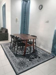 einen Holztisch und Stühle auf einem Teppich im Wohnzimmer in der Unterkunft HOMESTAY BERTAM SAFAR in Kepala Batas