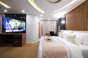 a bedroom with a large bed and a flat screen tv at Arabella Premium Residence - New Cairo in Cairo