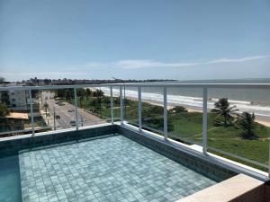 a balcony with a view of the beach and the ocean at Paradise Beach Flat in João Pessoa