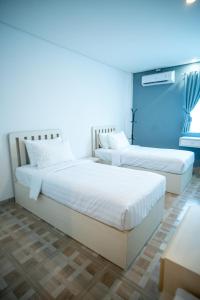 2 camas en una habitación con paredes azules en Elephant Inn and Suite by Sajiwa en Bandar Lampung