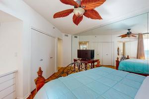 a bedroom with a bed and a ceiling fan at East Pass Towers 302 in Destin +20 photos
