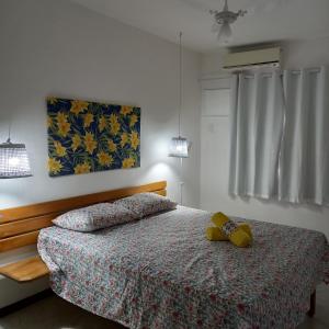 a bedroom with a bed with a teddy bear on it at Apartamento inteiro n.24 in Porto Seguro