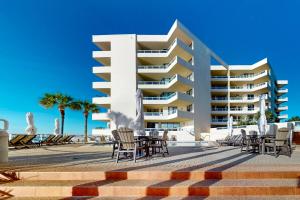 a hotel with chairs and tables in front of a building at East Pass Towers 302 in Destin