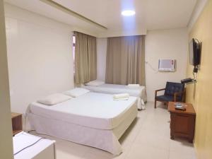 a hotel room with two beds and a television at Hotel Boa Viagem Aeroporto in Recife