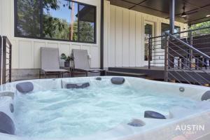 uma banheira de hidromassagem no pátio de uma casa em Luxurious Modernism with Private Hot Tub and Garage em Austin