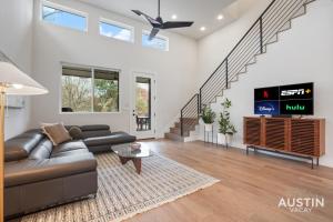 uma sala de estar com um sofá e uma televisão em Luxurious Modernism with Private Hot Tub and Garage em Austin