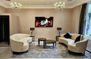 a living room with two chairs and a fireplace at Hyde Park International in London