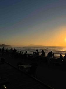 un gruppo di persone in piedi sulla spiaggia a guardare il tramonto di Design One bedroom with balcony a Bidart