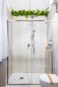 a bathroom with a shower with a toilet and plants at Kea Home, entire house in the heart of Naples in Naples