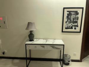 a table with a lamp on it in a room at 1 bed apartment infront of Centaurus in Islamabad